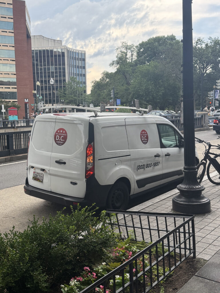 The Locksmith DC Company locksmith van parked near downtown Washington DC buildings.