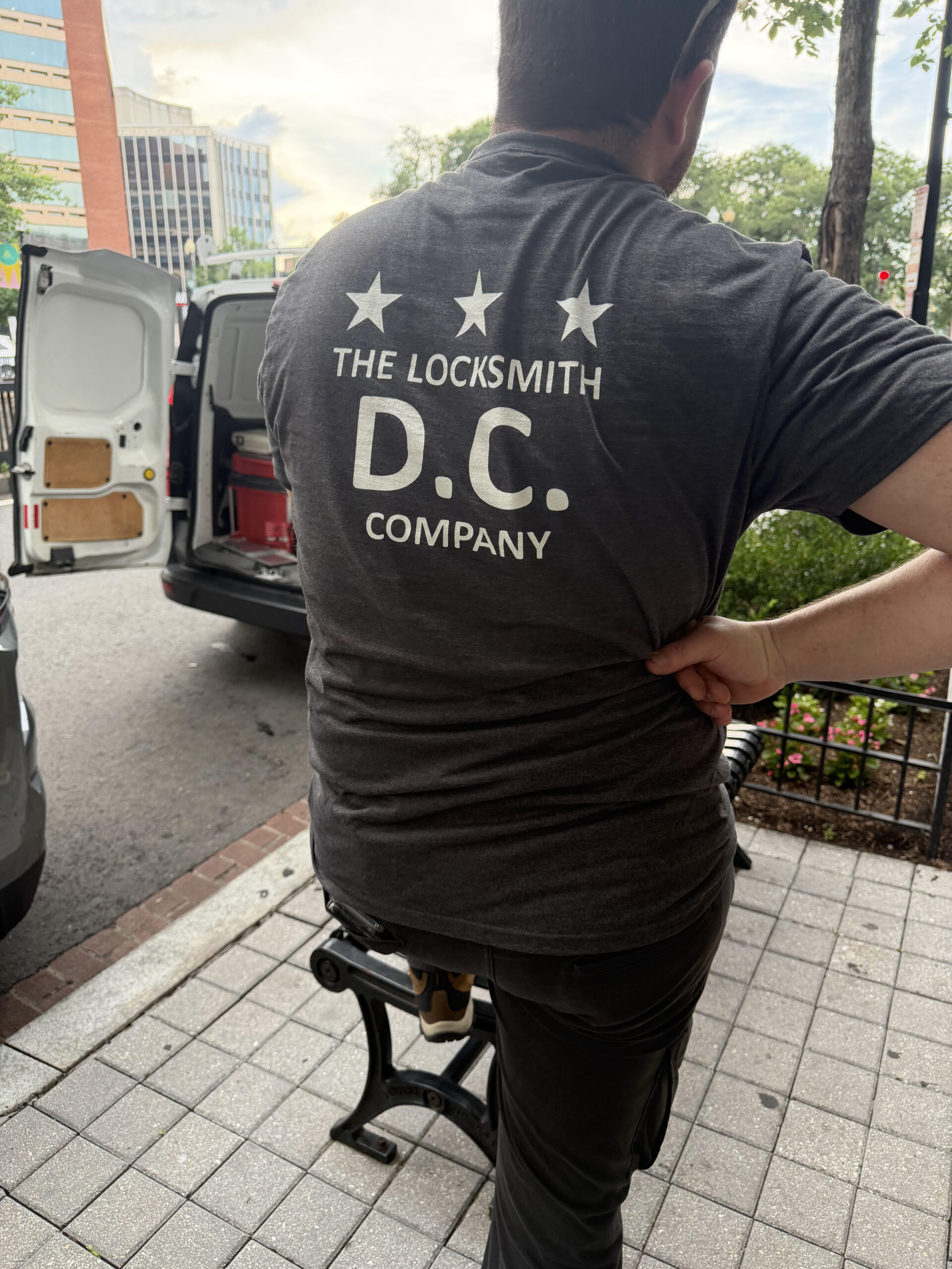 The Locksmith DC Company technician wearing branded shirt next to service van in Washington DC.